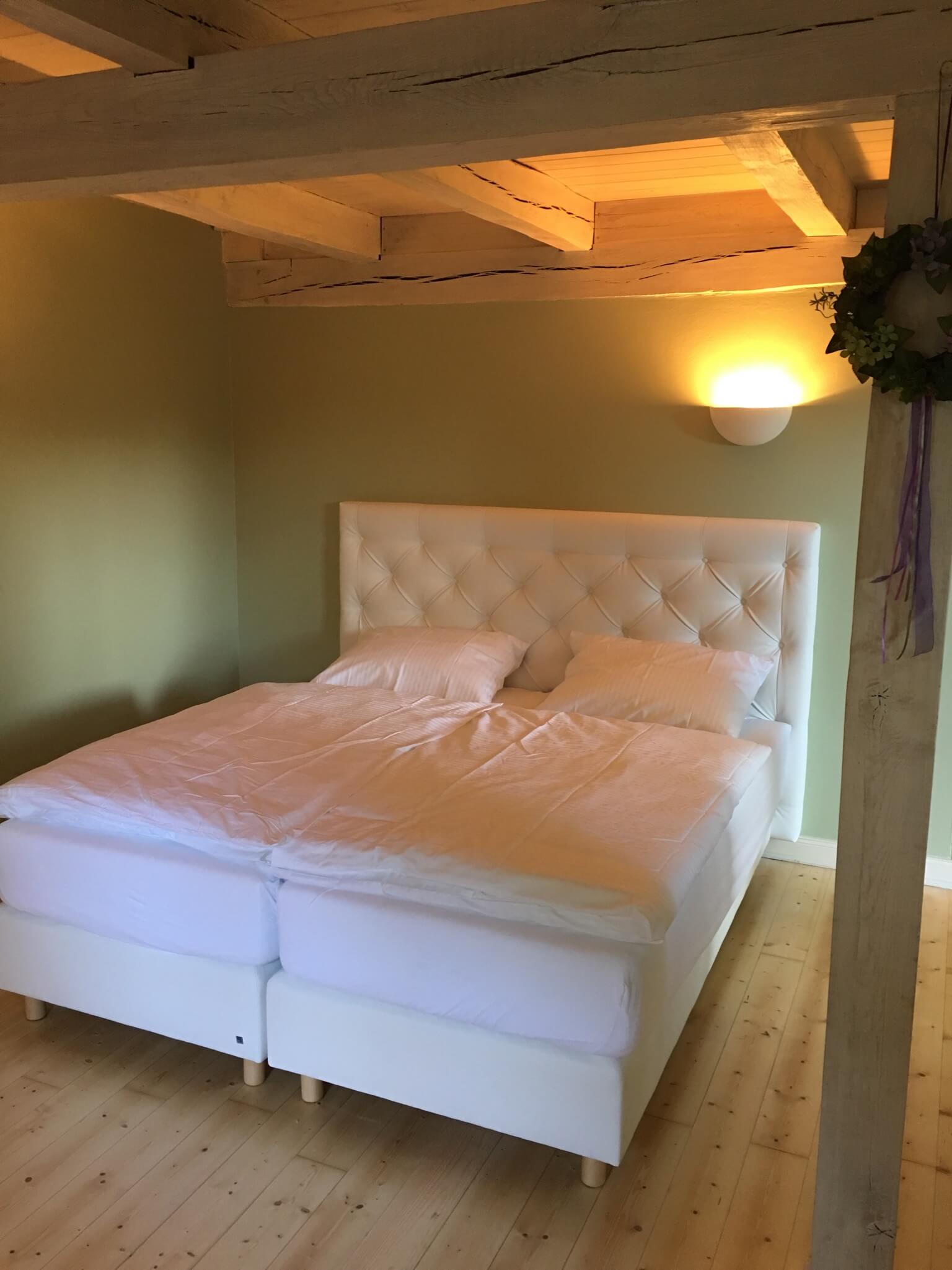 Cozy box spring king size bed on wooden floor